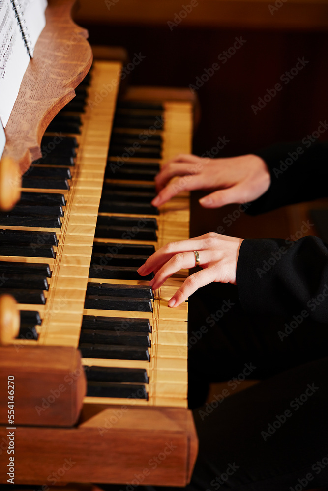 hands of a person playing the pipe organ