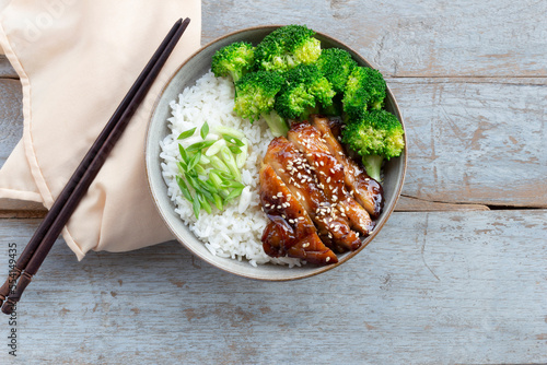 Healthy food teriyaki chicken has rice and vegetable in bowl on wood table.