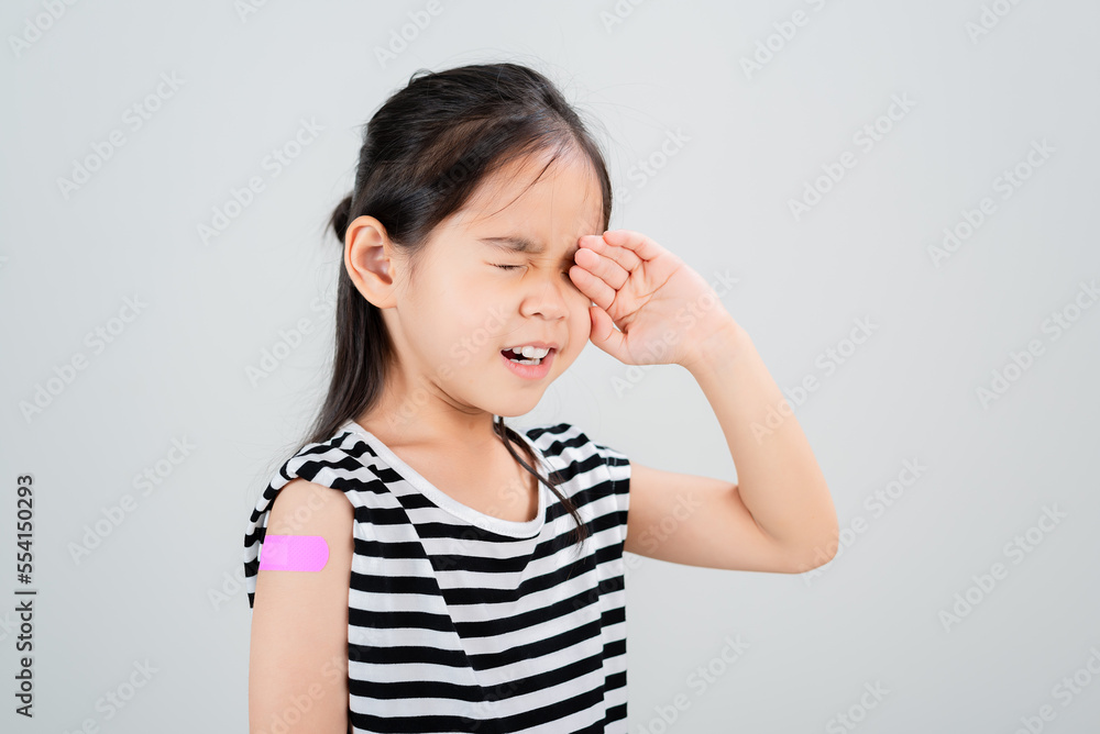 Asian little girl cry with bandage after virus vaccine Kid and child vaccination campaign. Protect your kid with vaccine concept Asian little girl cry with bandage after virus vaccine Kid and child vaccination campaign. Protect your kid with vaccine concept