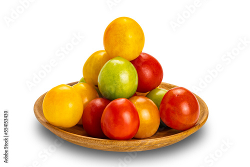 Side view pile of colorful freshly harvested organic cherry tomatoes in wooden plate isolated on white background with clipping path.
