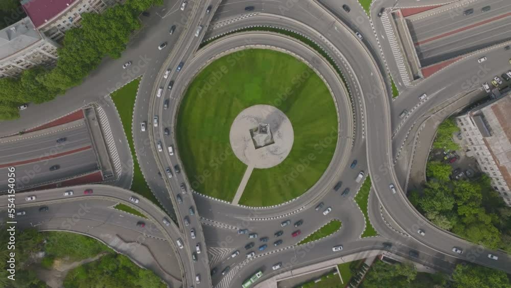 Ascending birds-eye-view shot of a busy roundabout junction filtering onto the highway Ascending birds-eye-view shot of a busy roundabout junction filtering onto the highway