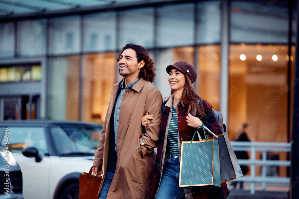 Happy couple crossing street while shopping in city. Happy couple crossing street while shopping in city.