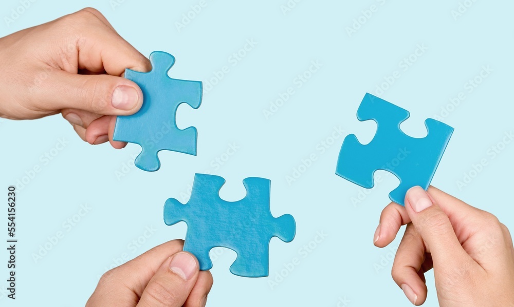 Business persons hands holding puzzle pieces Business persons hands holding puzzle pieces