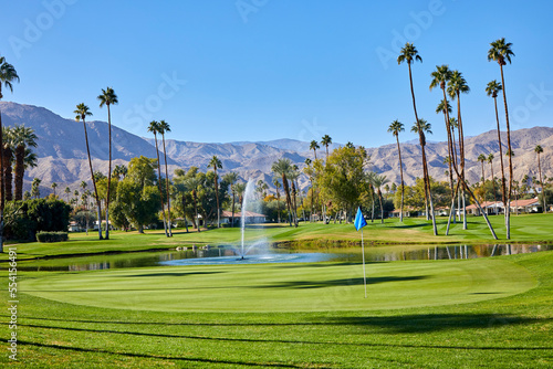 Golf course with mountains and palm trees in southern  California on a sunny day