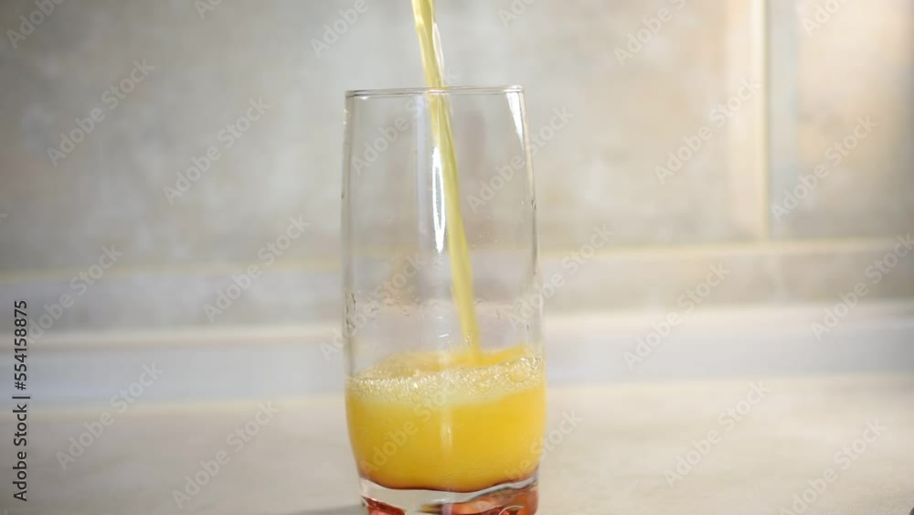 The yellow liquid is poured into a tall glass. Liquids come out bubbles, it foams and pours over the edge of the glass. The yellow liquid is poured into a tall glass. Liquids come out bubbles, it foams and pours over the edge of the glass.