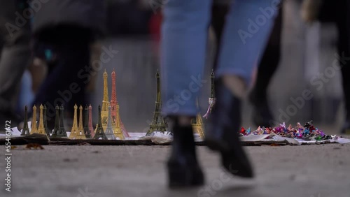 Legs Of People Walking In The Street With Illegal Street Vendor Eiffel Tower Souvenirs On The Ground In Paris, France. - zoom in photo