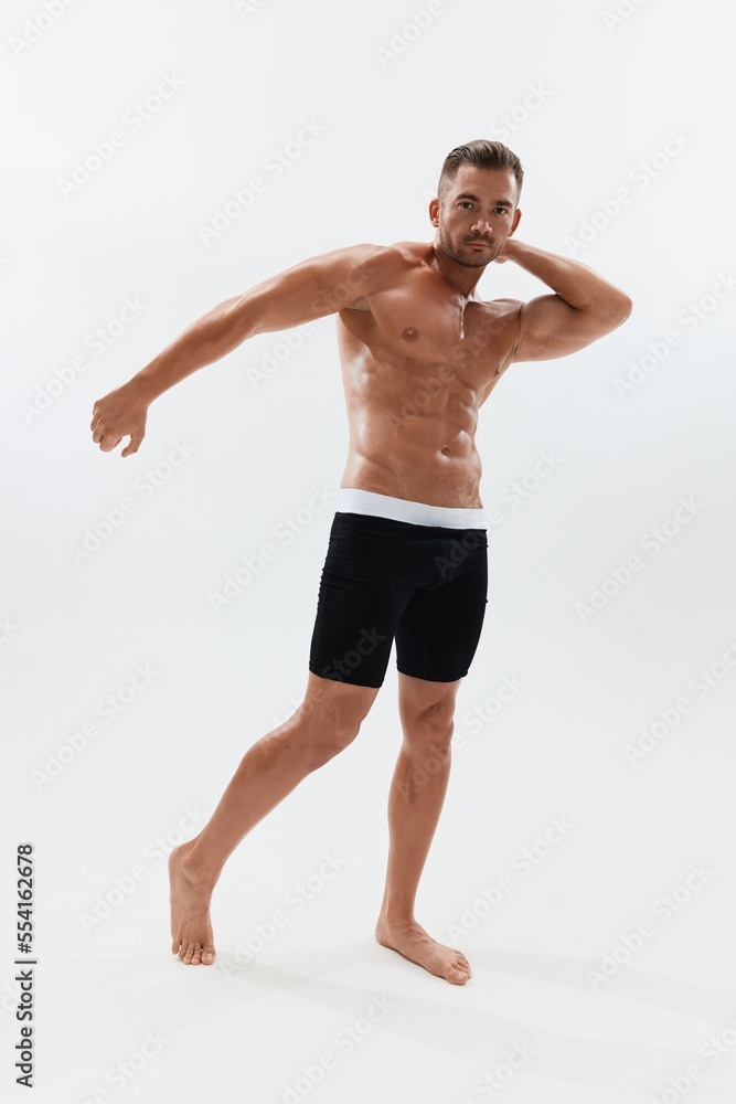 Man athletic body bodybuilder in briefs with naked torso abs full-length in the background, fitness classes. Advertising, sports, active lifestyle, competition, challenge concept.