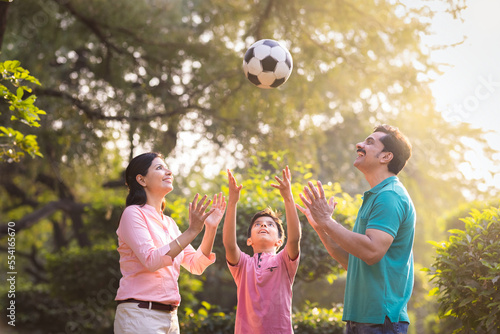 Happy indian family playing with football at park