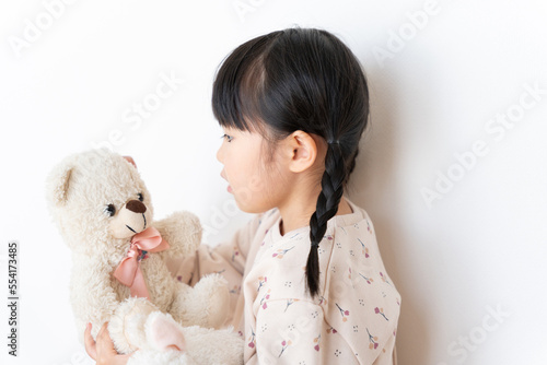 Fototapeta Naklejka Na Ścianę i Meble -  お気に入りのクマのぬいぐるみを抱っこする子供（育児・子育て・プレゼント・5歳）