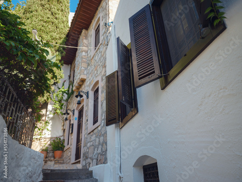 Fototapeta Naklejka Na Ścianę i Meble -  Marmaris is resort town on Turkish Riviera, also known as Turquoise Coast. Beautiful streets of old Marmaris. Narrow streets with stairs among houses with white bricks, green plants and flowers