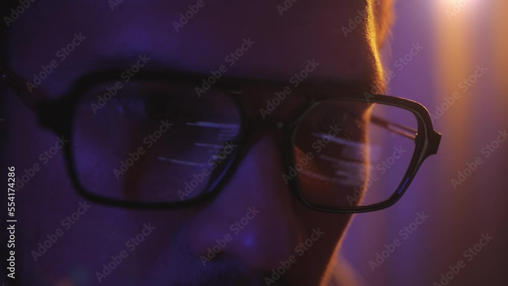 Close-up face of software engineer working on laptop. Line of code in reflection. Developer or hacker working on innovative application using computer. Close-up face of software engineer working on laptop. Line of code in reflection. Developer or hacker working on innovative application using computer.