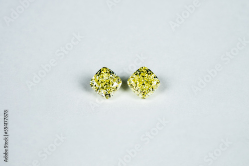 Cushion fancy yellow diamonds on white surface