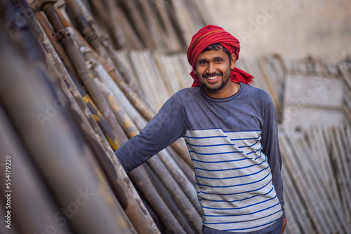A DAILY WAGE LABOURER STANDING AND LOOKING AT CAMERA photo