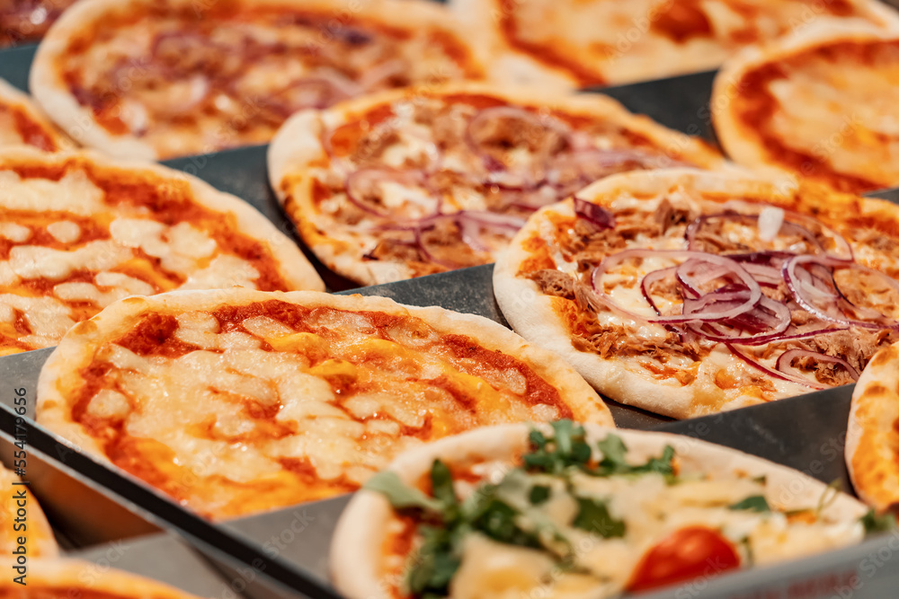 Many Italian pizza on the counter of the bakery store Many Italian pizza on the counter of the bakery store