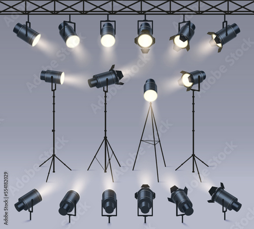 Realistic spotlights. Lamp on tripod stand, photo studio or stage light equipment. Spotlight with light beam glow effect vector set