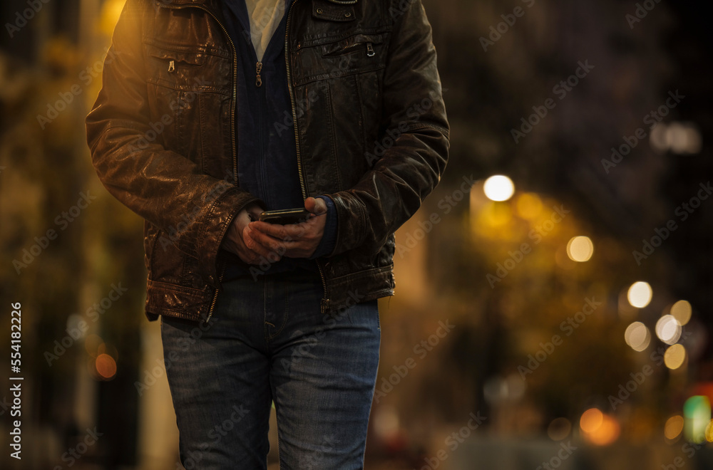 Closeup of adult man using mobile phone on street at night Closeup of adult man using mobile phone on street at night