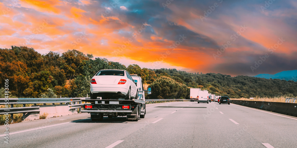 Tow Truck Transporting Car Or Help On Road Transports Wrecker Broken Car. Car Service Transportation Concept. Auto Towing, Tow Truck For Transportation Faults And Emergency Cars . Tow Truck Moving In Tow Truck Transporting Car Or Help On Road Transports Wrecker Broken Car. Car Service Transportation Concept. Auto Towing, Tow Truck For Transportation Faults And Emergency Cars . Tow Truck Moving In