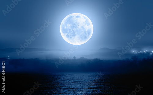 Night sky with blue moon in the clouds over the calm blue sea  Elements of this image furnished by NASA