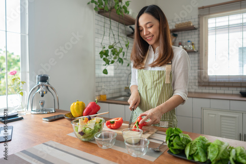 Asian women cutting vegetables for preparing healthy food in the kitchen at home