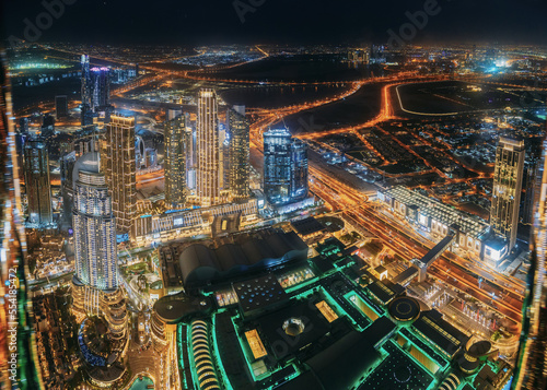 Aerial view of evening night illuminations scenic view of skyscraper in Dubai. Street night traffic in Dudai skyline. Urban background of Dubai, UAE, United Arab Emirates. night illuminations toned