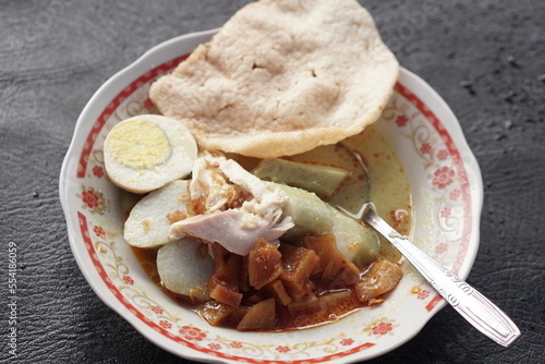 Lontong opor is Indonesian traditional food made from chicken cooked with coconut milk and spices. Served with egg, compressed rice cake, and prawn cracker.