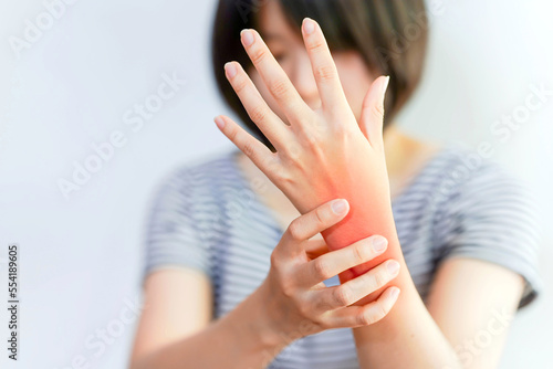 Fotografia Women's wrist pain from using the hands to work repetitively for a long time or from general diseases of the body such as diabetes, thyroid gland, tumors around the wrist
