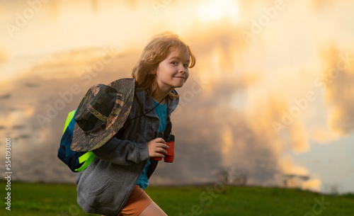 Child with backpack, traveller or explorer. Concept of exploration and discovery. Kid travel on nature outdoors, adventure and tourism, leisure trips. Summer vacation, tourism.