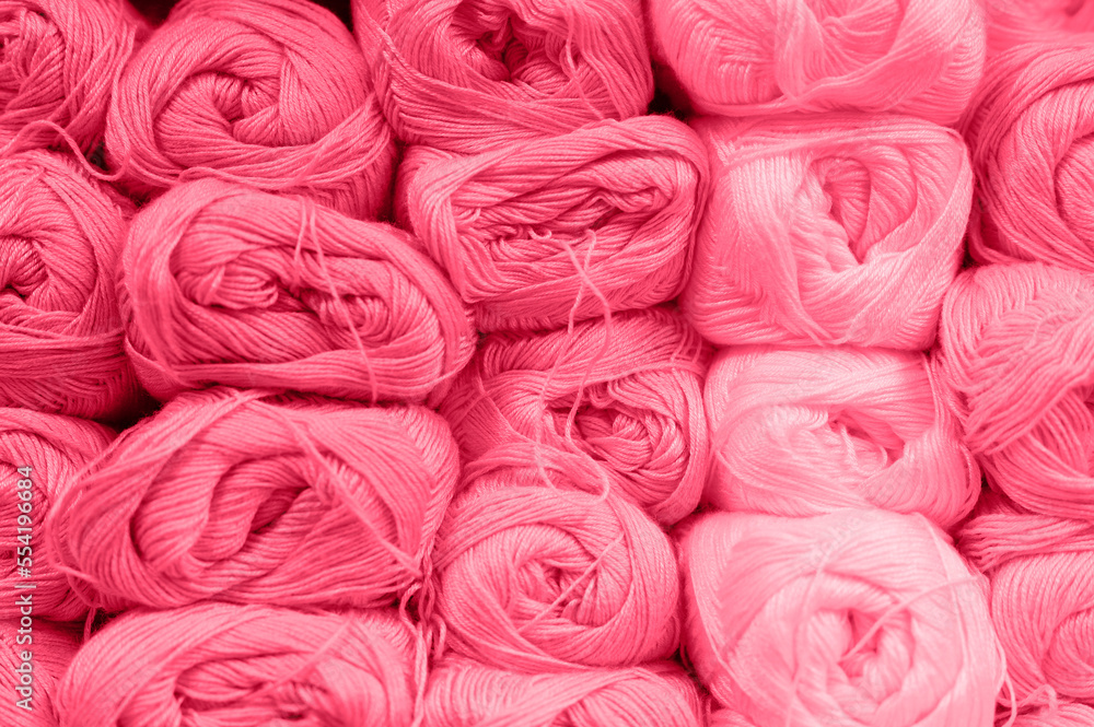 background of rows skeins of fluffy wool yarn for knitting soft red pink purple hue colors. toned in viva magenta, trend color of the year 2023 background of rows skeins of fluffy wool yarn for knitting soft red pink purple hue colors. toned in viva magenta, trend color of the year 2023