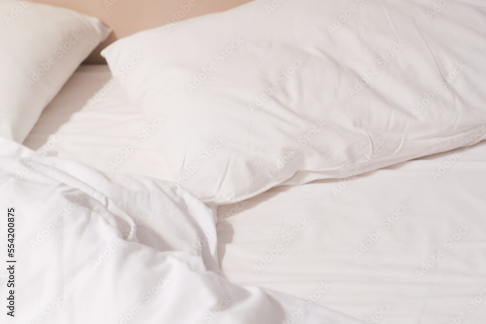 Wrinkled white blanket and pillows on comfortable bed in the morning. Wrinkled white blanket and pillows on comfortable bed in the morning.