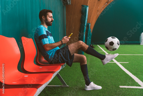 Cinematic image of a soccer freestyle player making tricks with the ball on a artificial grass court indoor. Concept about sport and people lifestyle 