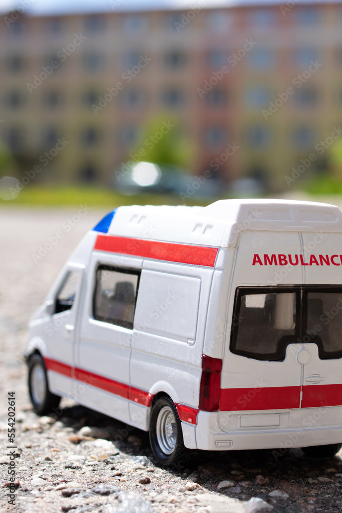 Fototapeta premium Model of an ambulance car on the background of the city