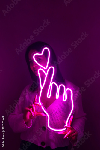 Beautiful girl with neon signs. Pink neon sign love and like. Trendy style. Neon sign. Custom neon. Home decor.