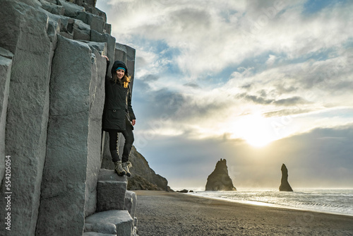 Obraz na płótnie posing woman is indulging on basaltic rock at Reynisfjara black Beach w salonie
