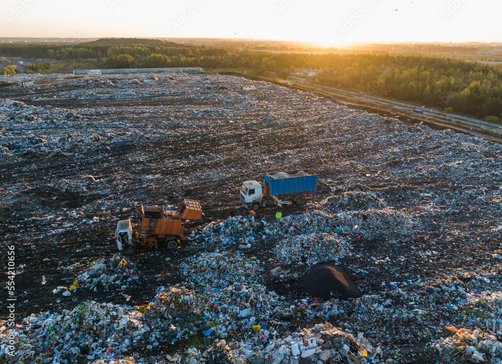 Garbage truck unloads rubbish in landfill. Landfill waste disposal. Garbage dump with waste