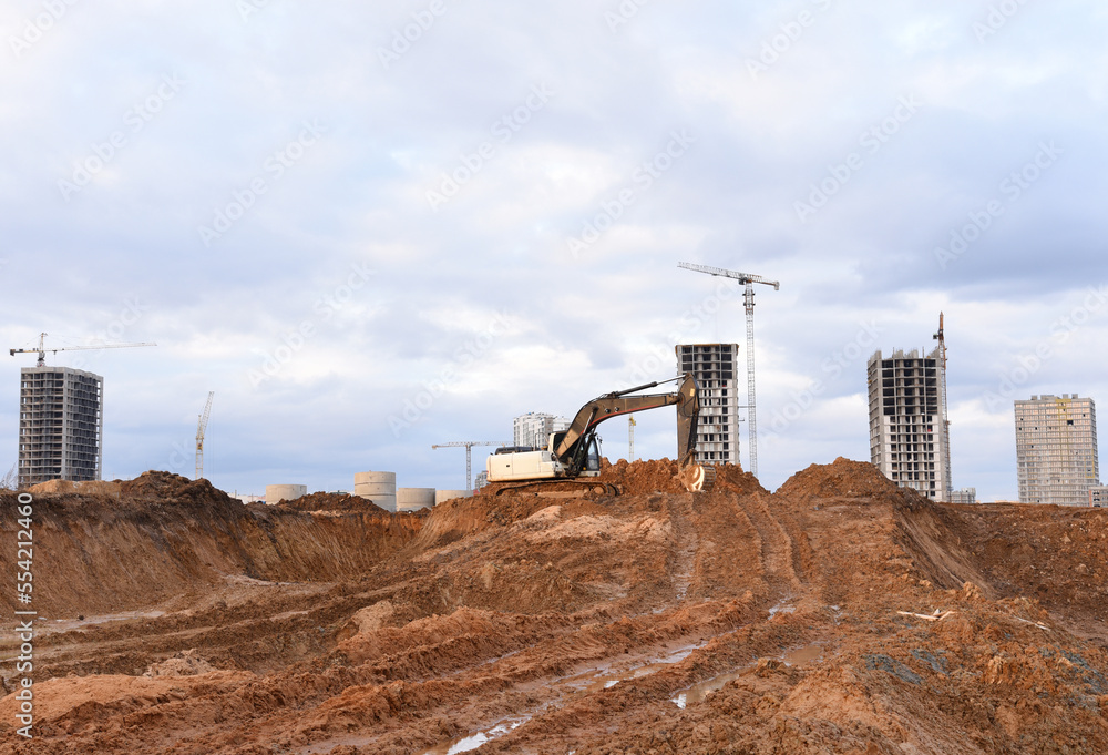 Excavator dig ground at construction site. Dig foundation. Construction of residential buildings, renovation program. Earthmover on groundwork. Building construction. Excavator on earthmoving.