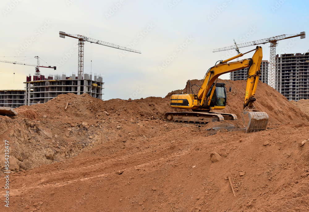 Excavator dig ground at construction site. Dig foundation. Construction of residential buildings, renovation program. Earthmover on groundwork. Building construction. Excavator on earthmoving. Excavator dig ground at construction site. Dig foundation. Construction of residential buildings, renovation program. Earthmover on groundwork. Building construction. Excavator on earthmoving.