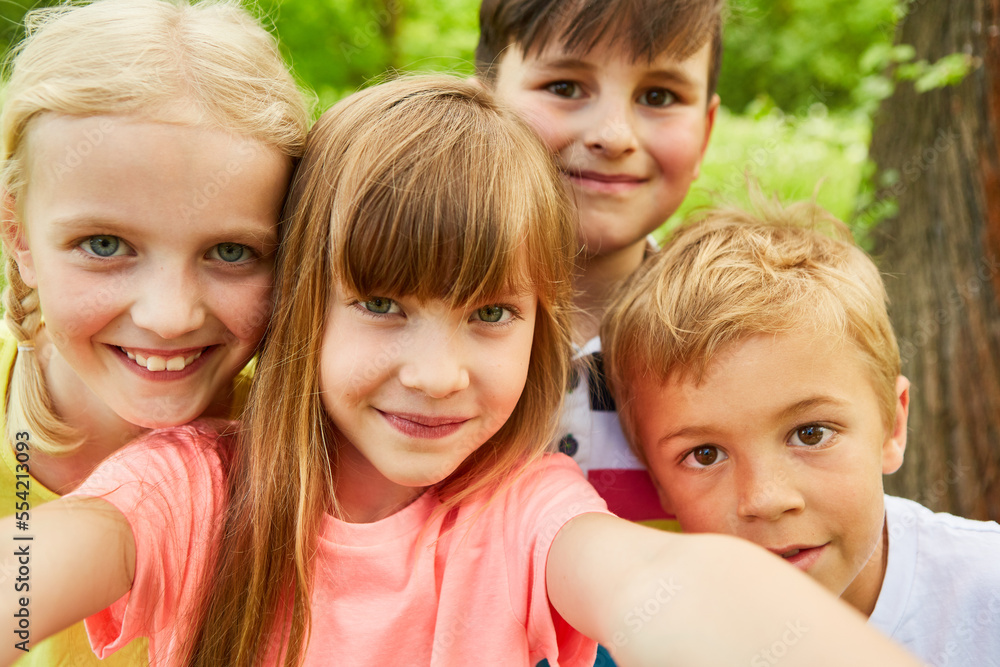 Group of children taking selfie photo with smartphone in nature Group of children taking selfie photo with smartphone in nature