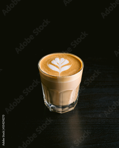 cup of coffee with latte art on black background
