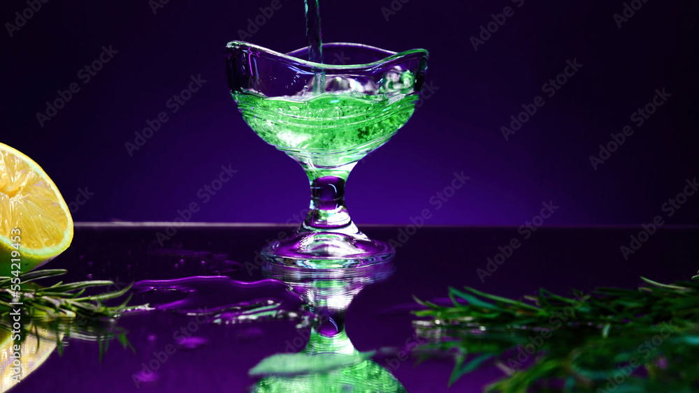 Close up of green drink in a glass on a dark blue background. Stock clip. Silhouette of a glass with a cocktail.