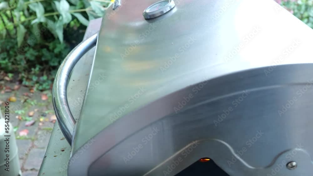 BBQ Closeup shot. Guy is opening and closing BBQ grill. Different