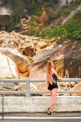 slender girl in short shorts looks back at the background of the gorge © Alevtina