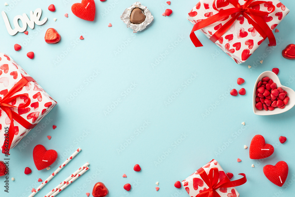 Valentine's Day concept. Top view photo of gift boxes heart shaped candles candies inscription love straws and saucer with sprinkles on isolated pastel blue background with empty space in the middle