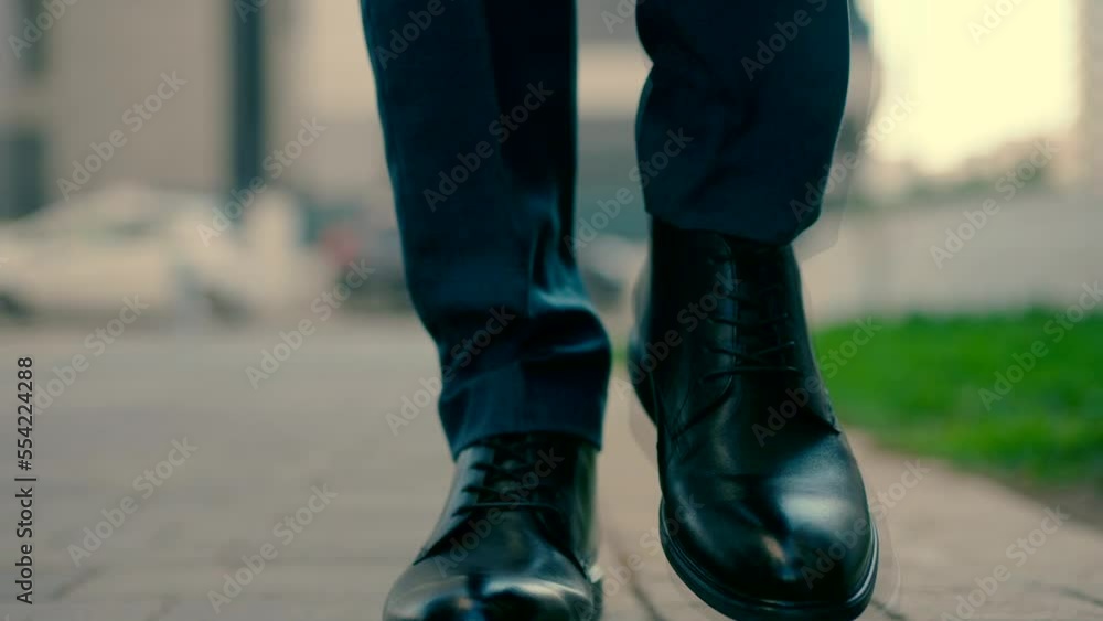 Floor and front shot of a man's legs wearing elegant shoes walking towards the camera. Close-up video shooting in slow motion Floor and front shot of a man's legs wearing elegant shoes walking towards the camera. Close-up video shooting in slow motion