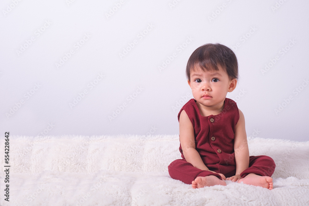Happy Little Baby Girl Sitting On Bed Looking Smiling In Bedroom At Home. Advertisement Banner With Cute Child Posing Indoor. Copy Space For Your Text. Happy Little Baby Girl Sitting On Bed Looking Smiling In Bedroom At Home. Advertisement Banner With Cute Child Posing Indoor. Copy Space For Your Text.