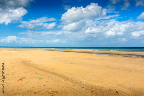 Beautiful beaches with gold sand and clear blue water under a blue cloudy sky. France has some wonderful beaches like only Caribbean have.