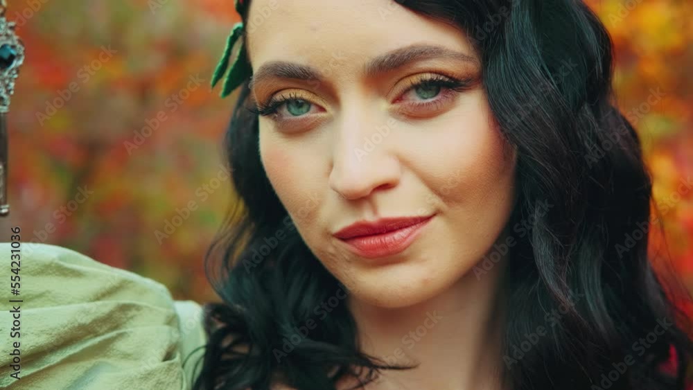 Art portrait fantasy woman queen holding secret silver old key in hand finger on lips sign gesture of silence. autumn forest nature. Beauty face. Yellow foliage. Princess girl. vintage green dress Art portrait fantasy woman queen holding secret silver old key in hand finger on lips sign gesture of silence. autumn forest nature. Beauty face. Yellow foliage. Princess girl. vintage green dress