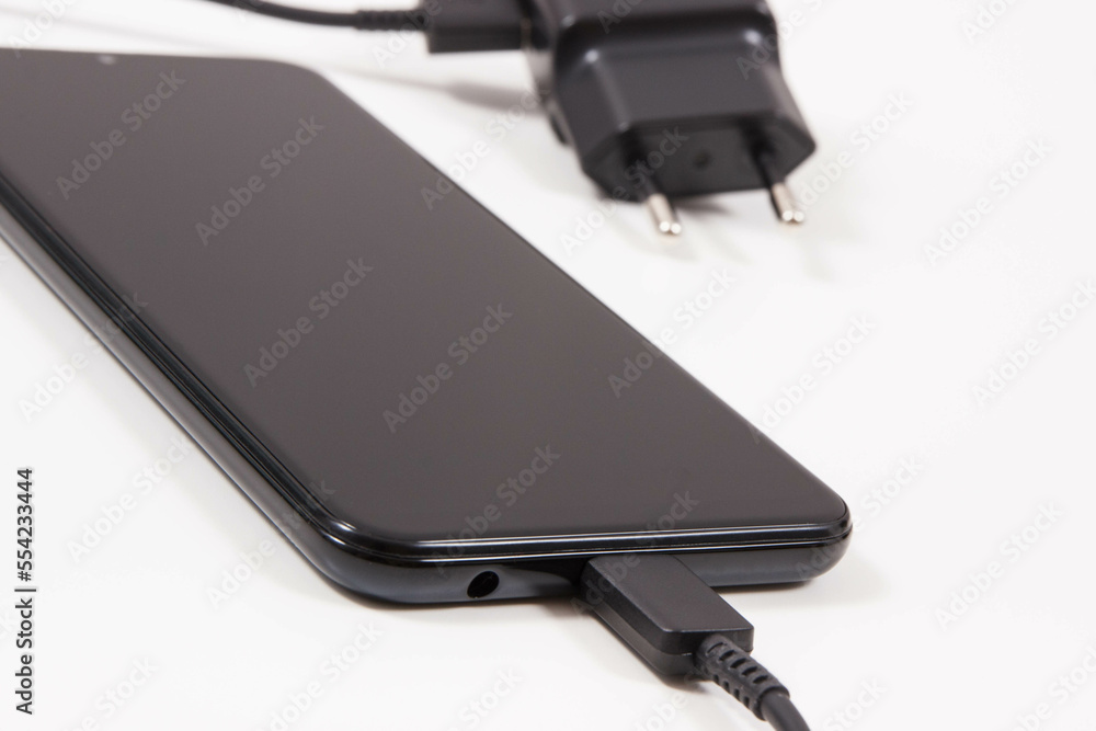 Mobile phone with connected plug of charger. Smartphone charging Mobile phone with connected plug of charger. Smartphone charging