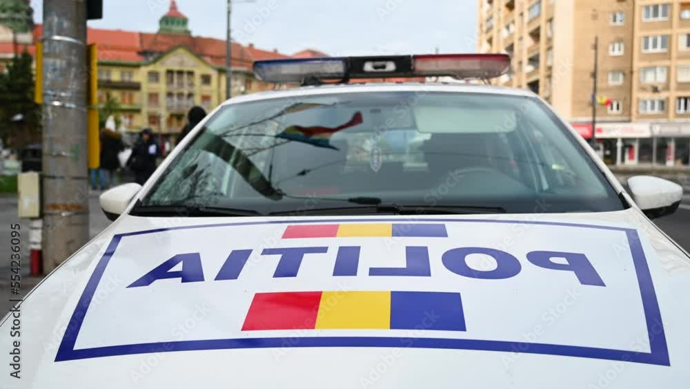 Police patrol car in Romania with flashing lights. Front view of a police car with the lettering Police patrol car in Romania with flashing lights. Front view of a police car with the lettering