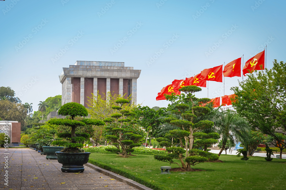 Obraz premium communist flag of Vietnam fluttering on the background of the mausoleum of Ho Chi Minh