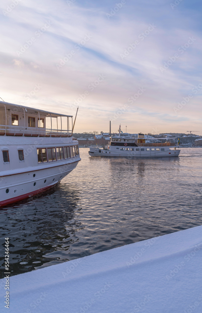 Down town bay view the Town City Hall and moored commuting boats at a pier a pale snowy winter day in Stockholm
